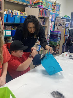  A student practices dusting for fingerprints as guided by his instructor.